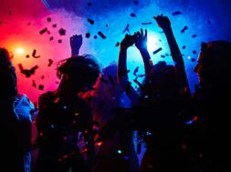 Silhouettes of dancers moving in confetti